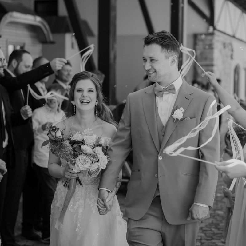 Hochzeitspaar beim Einzug inmitten ihrer Gäste